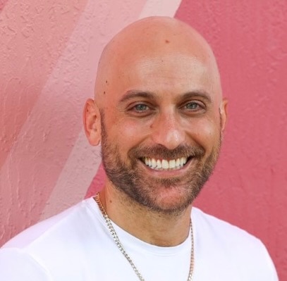 A person with a bald head wearing a shirt and tie.